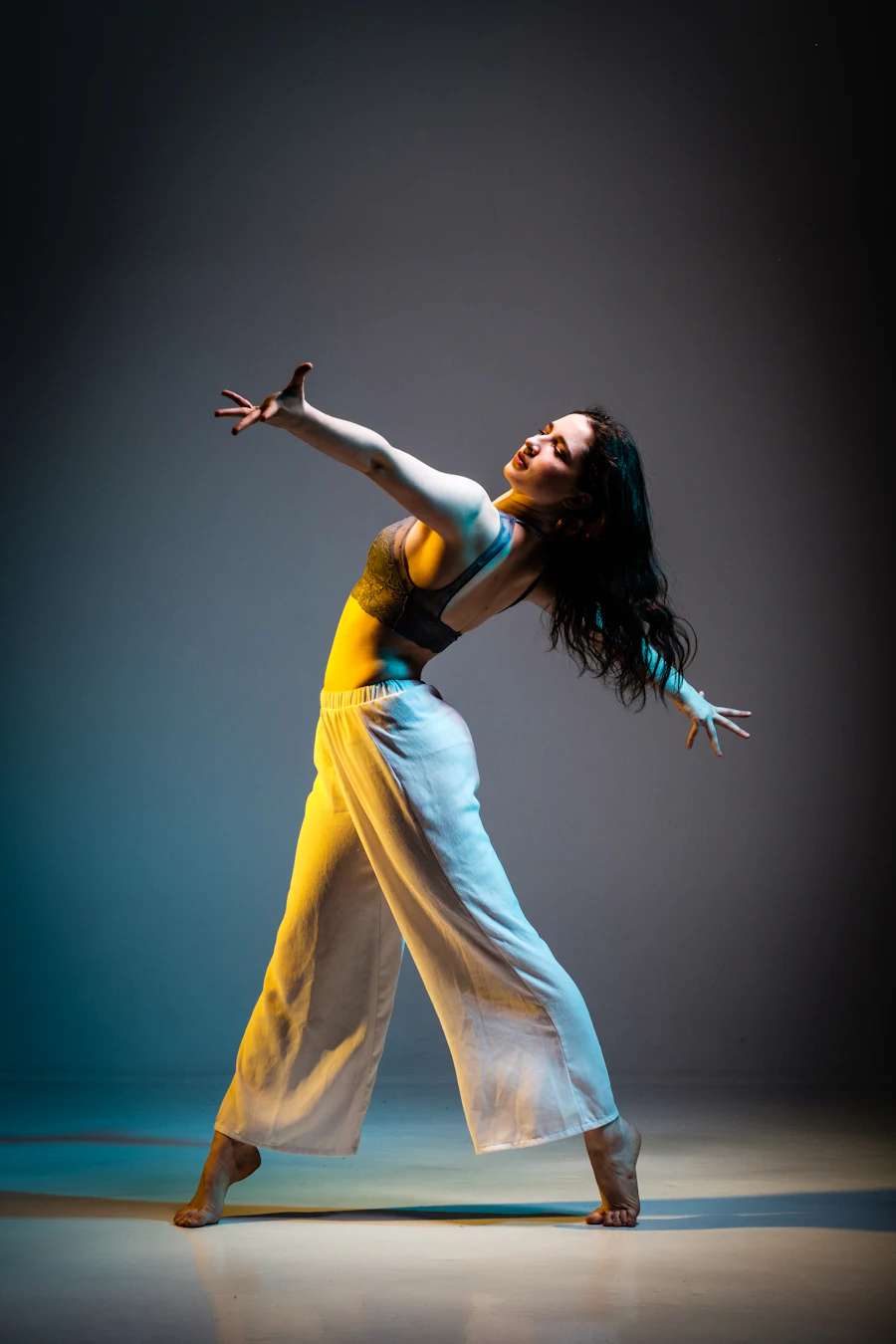 Dancer mid-leap under stage lights